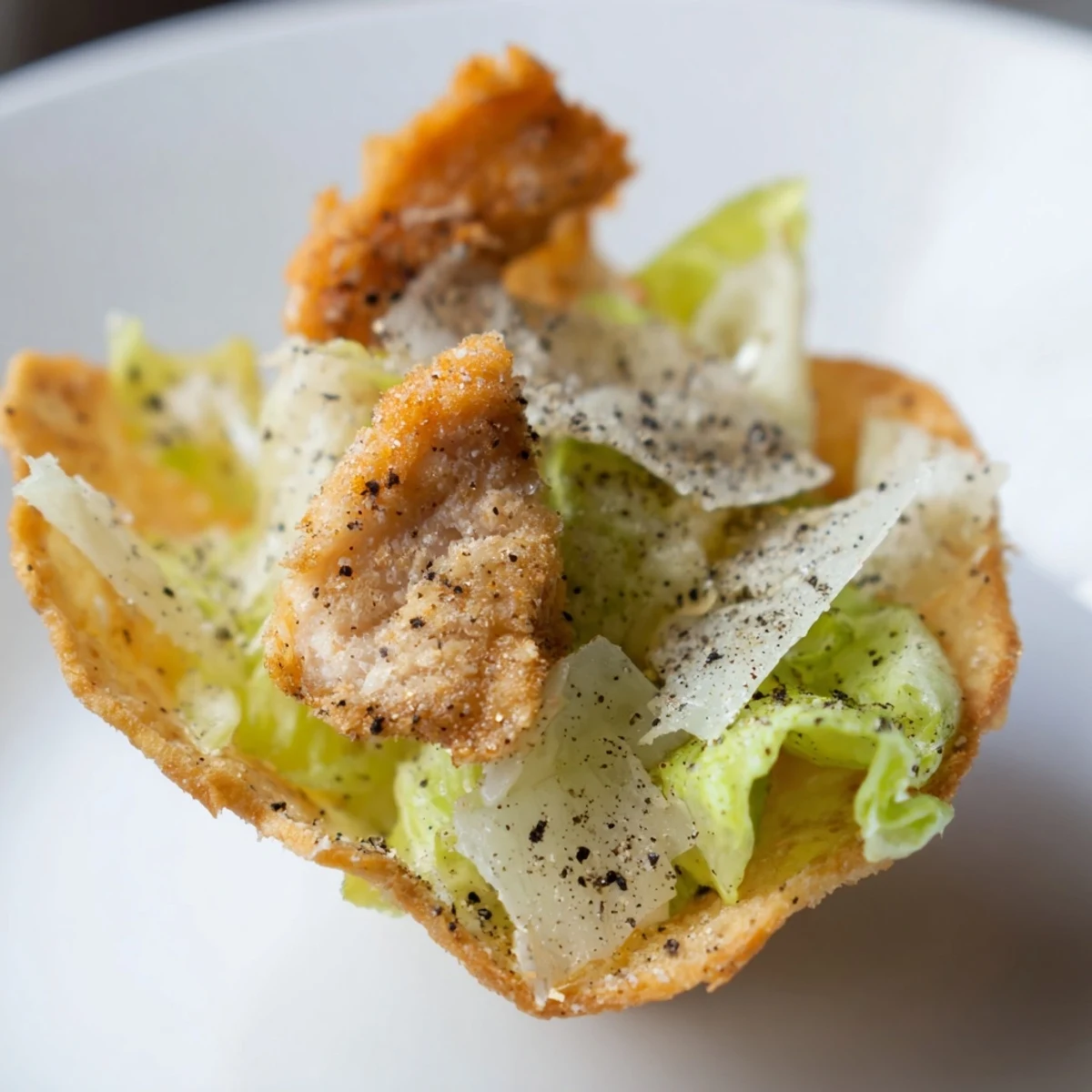 Freshly baked golden potato chips topped with dressed romaine, crispy chicken strips, and shaved parmesan for a crunchy Caesar-inspired bite.