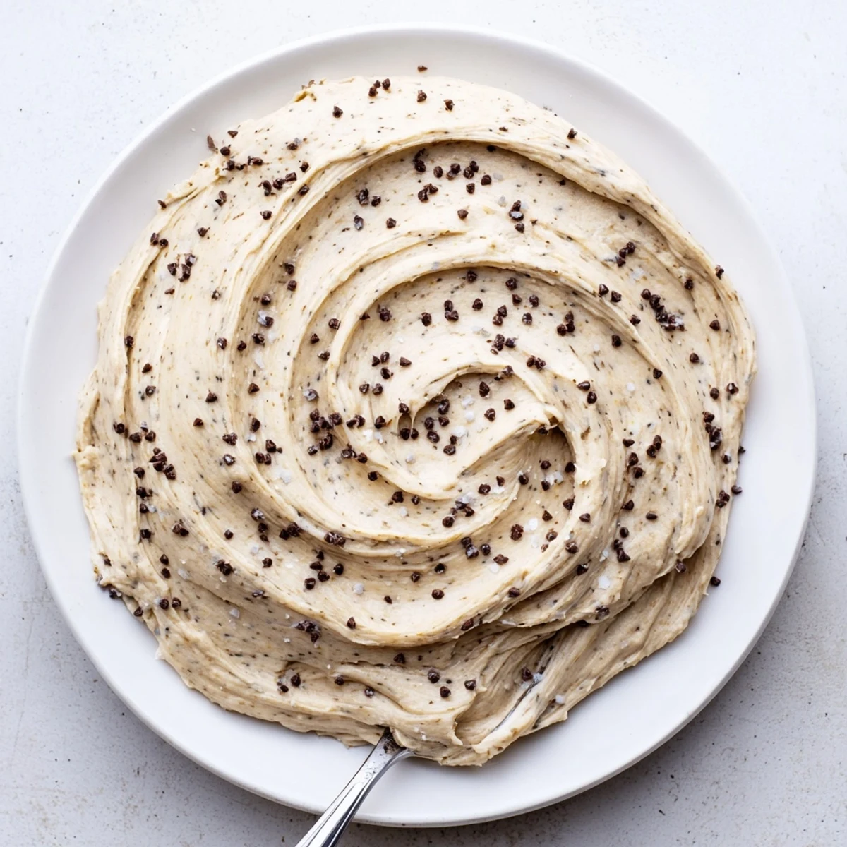 A bowl of smooth, creamy Cookie Dough Frosting loaded with mini chocolate chips and a hint of vanilla.