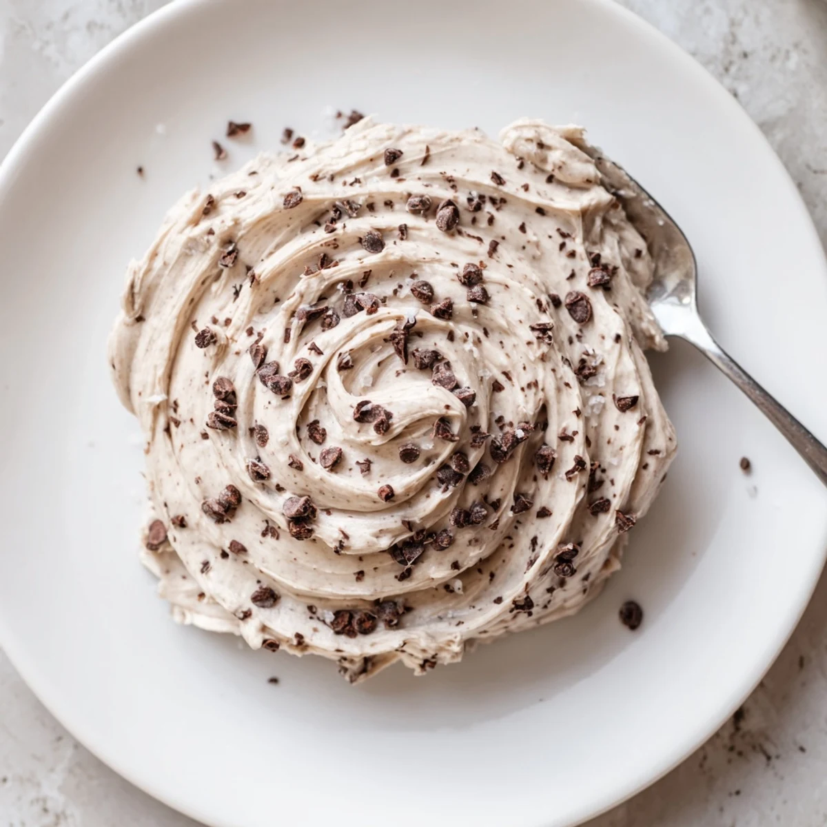 Thick, spoonable Cookie Dough Frosting with visible flour texture and chocolate chips, perfect for spreading on cupcakes.