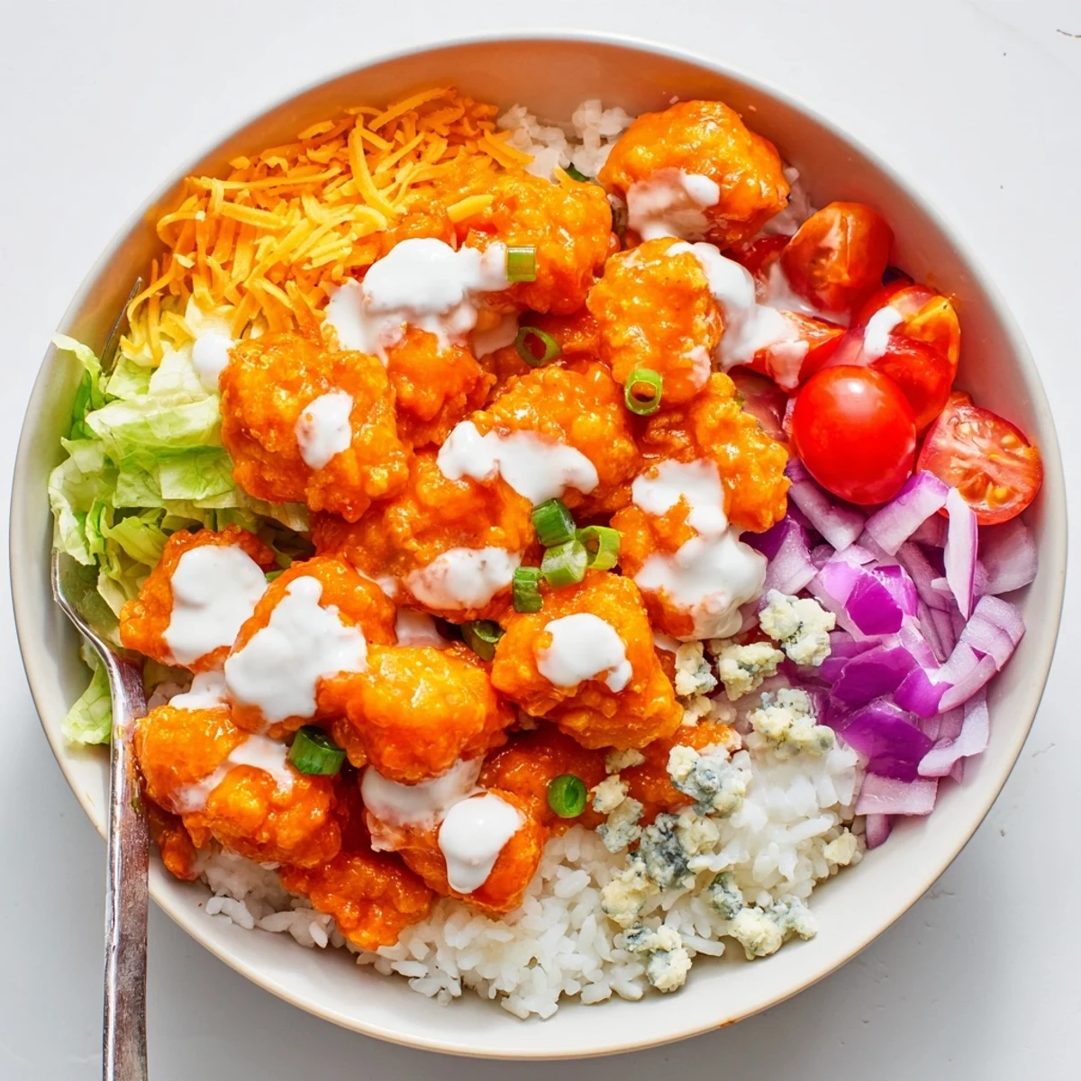 Juicy buffalo chicken pieces tossed in creamy ranch, served over fluffy rice with crisp lettuce and shredded carrots.
