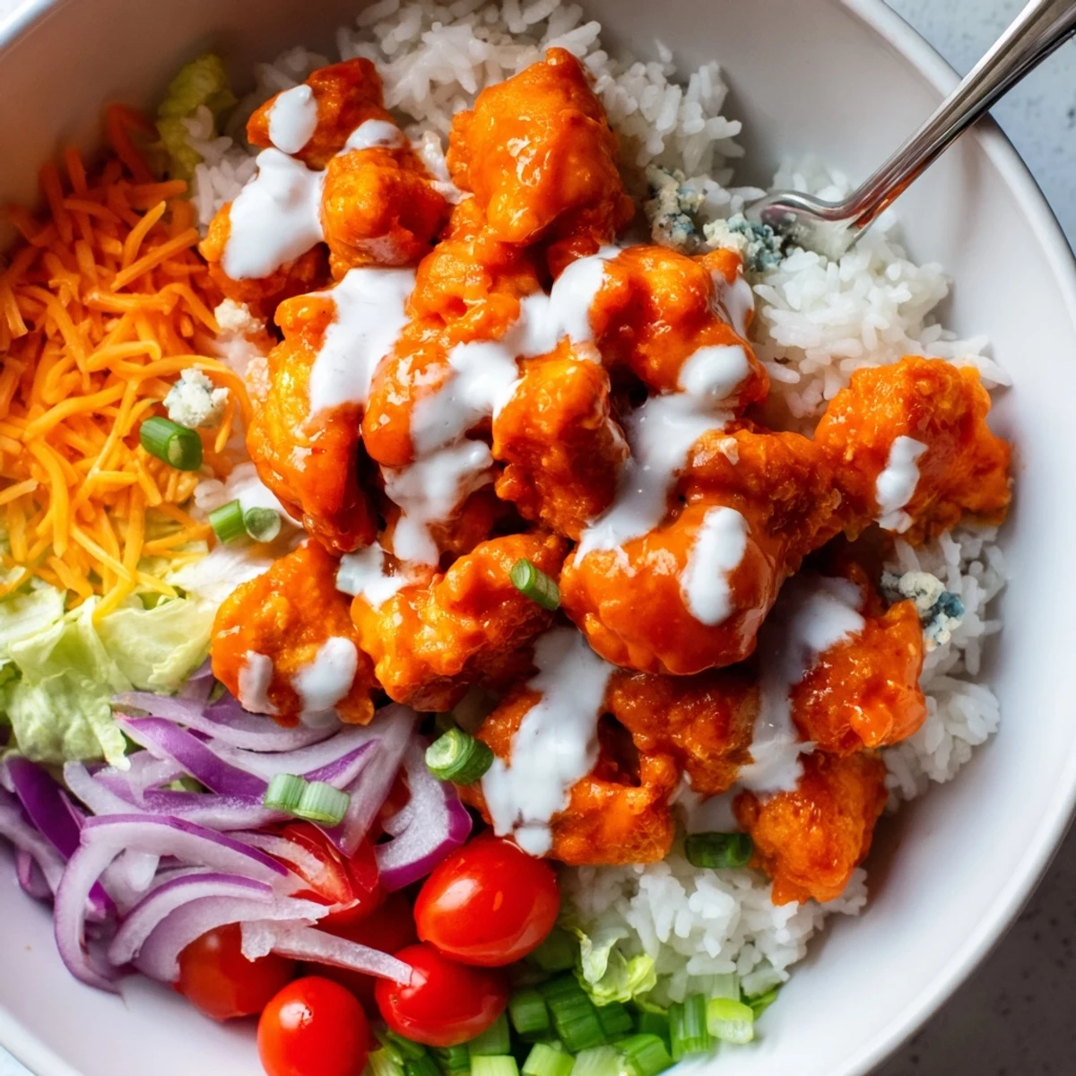 Spicy buffalo sauce and cool ranch drizzle make these hearty Buffalo Chicken Bowls perfect for a satisfying dinner.
