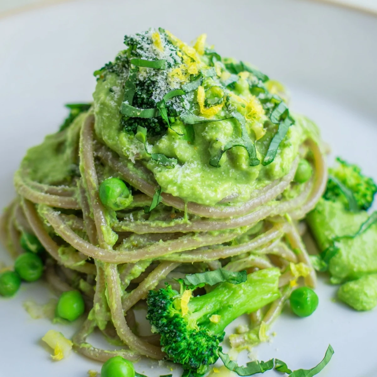 Creamy Veggie Smuggler Avocado Pasta topped with grated Parmesan and fresh basil leaves.