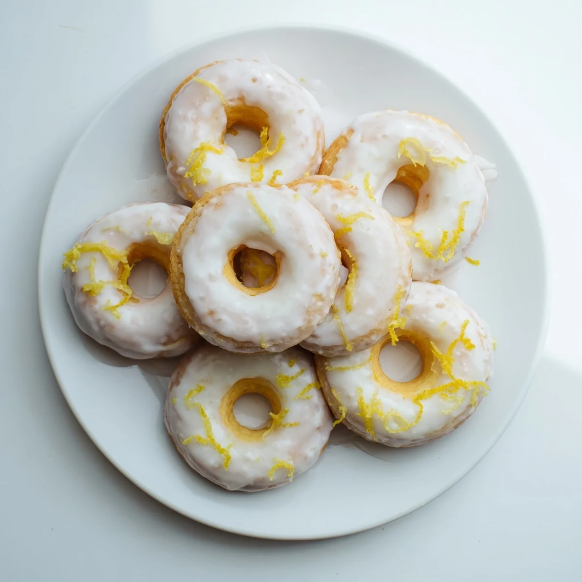 Chewy gluten-free lemon mochi donuts topped with zesty lemon glaze and fresh zest