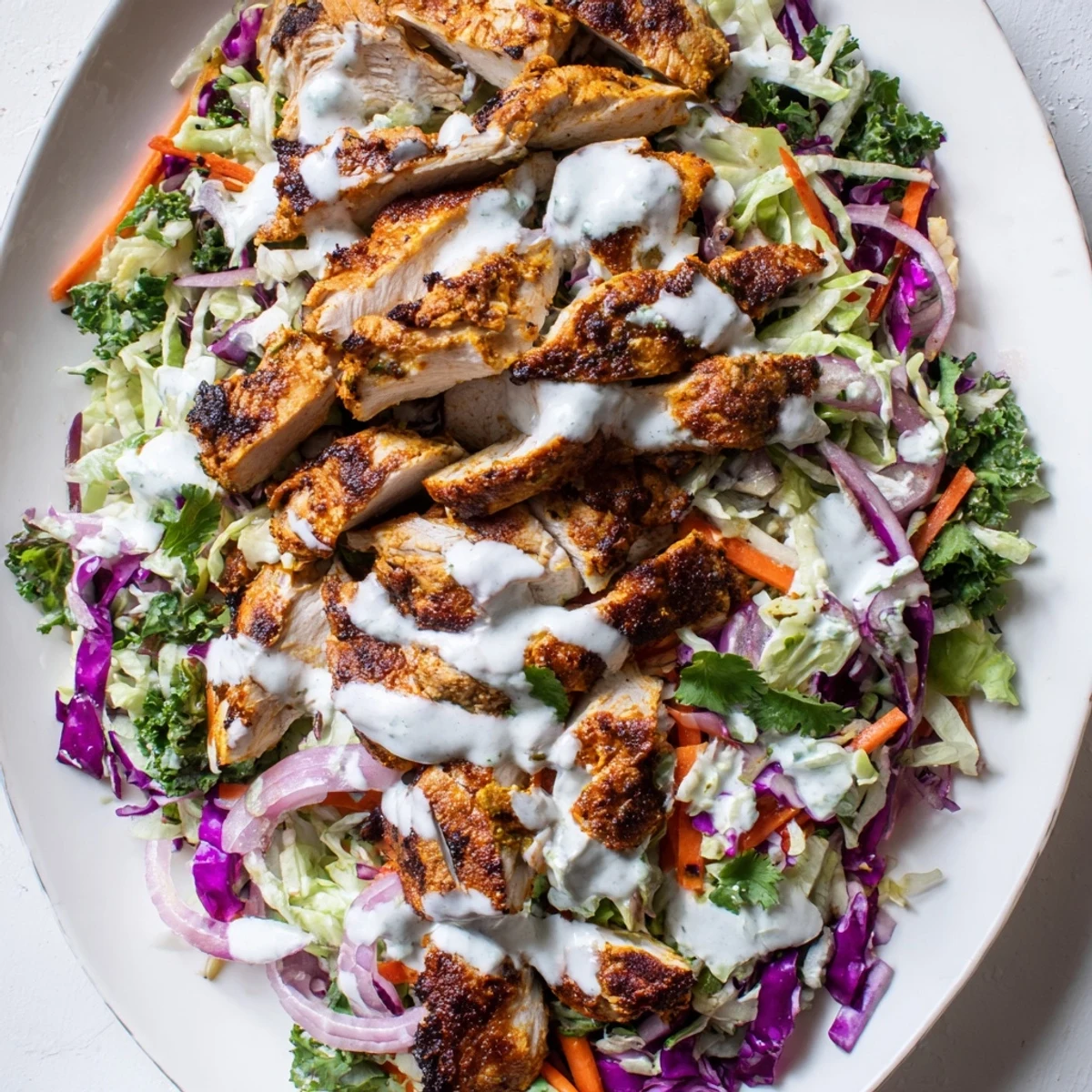 Vibrant bowl of curried chicken lime coleslaw topped with refreshing mint yogurt sauce