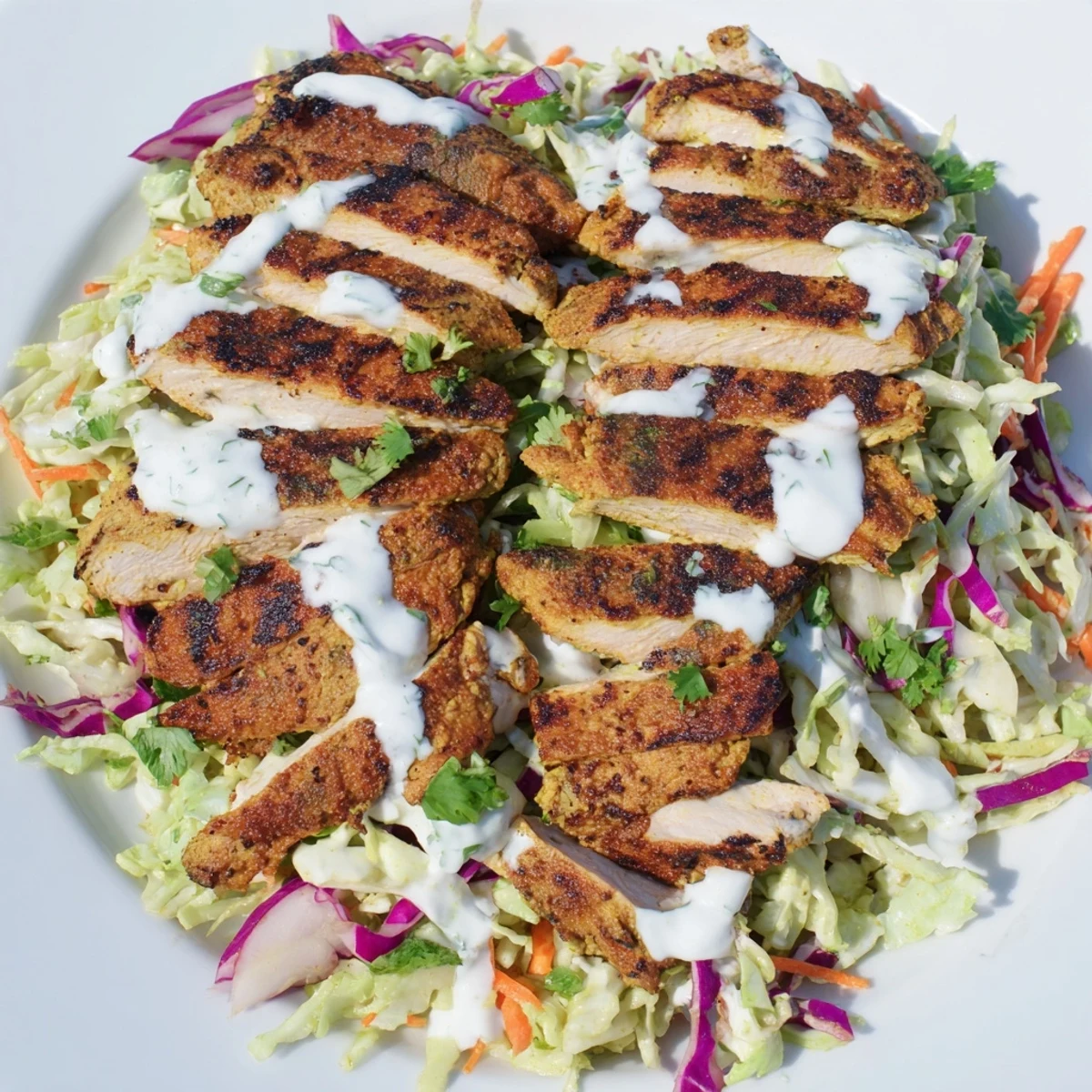 Spiced grilled chicken served atop crisp purple green cabbage slathered with mint yogurt