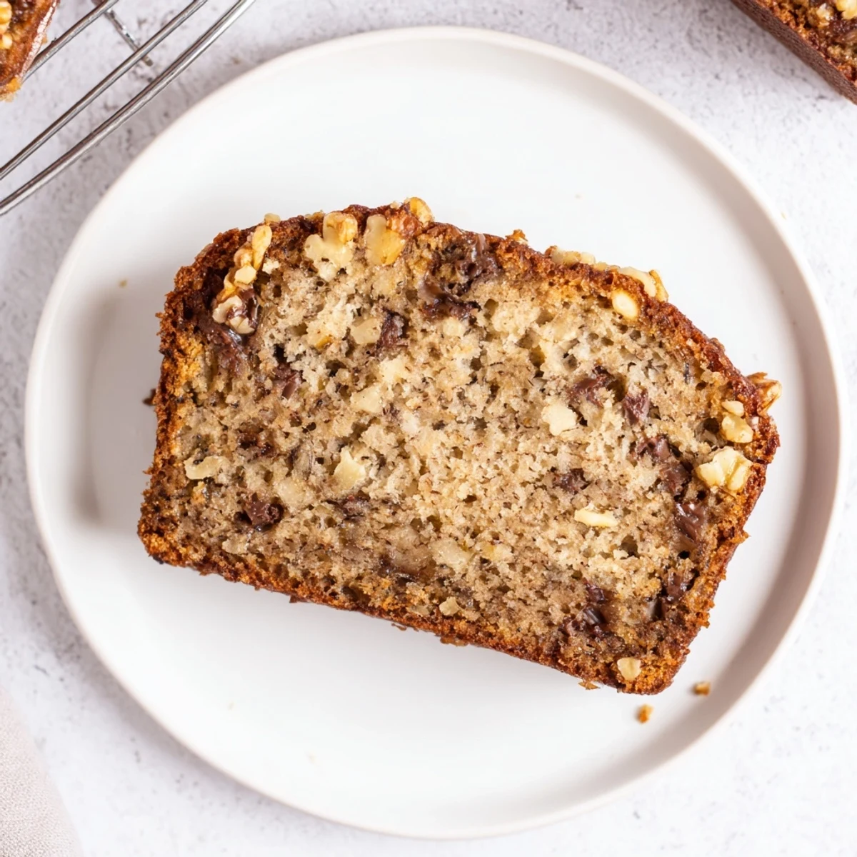 Freshly baked moist banana bread cooling on wire rack, perfect for breakfast or snacking