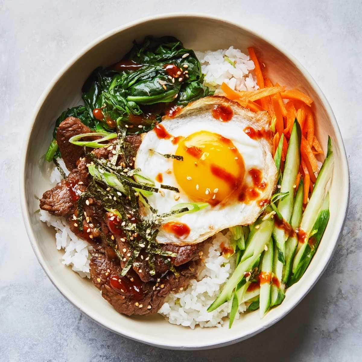 Sunny-side egg crowns this savory Korean-Inspired Breakfast Bowl served over warm rice with seasoned beef, bean sprouts, and sesame seed garnish.