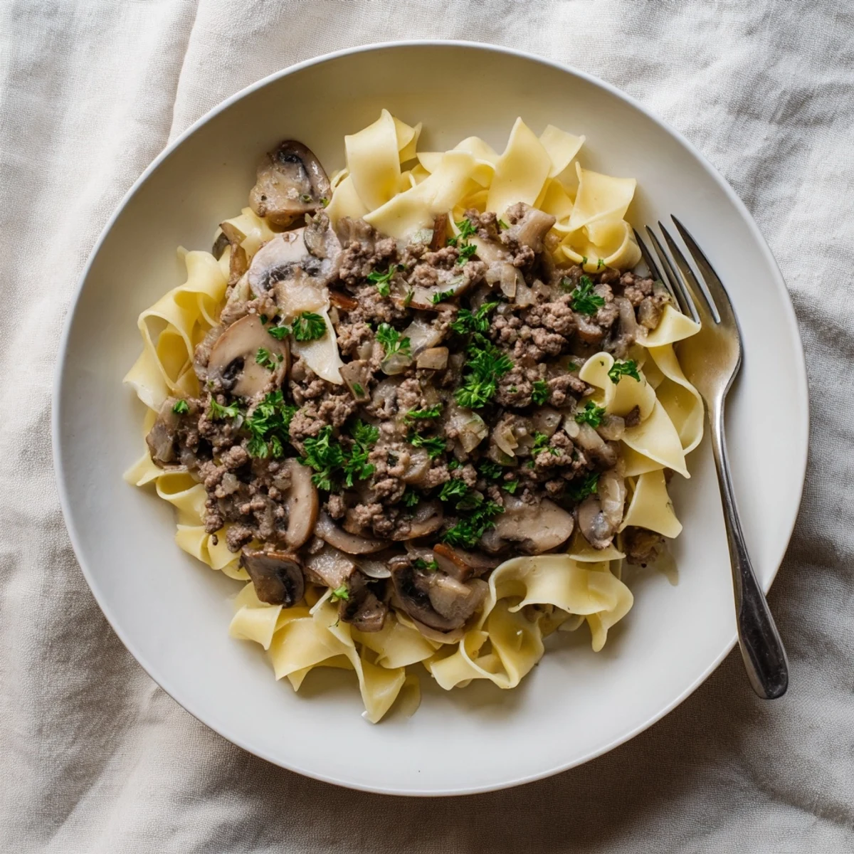 Hearty hamburger stroganoff served in a bowl with savory sour cream sauce
