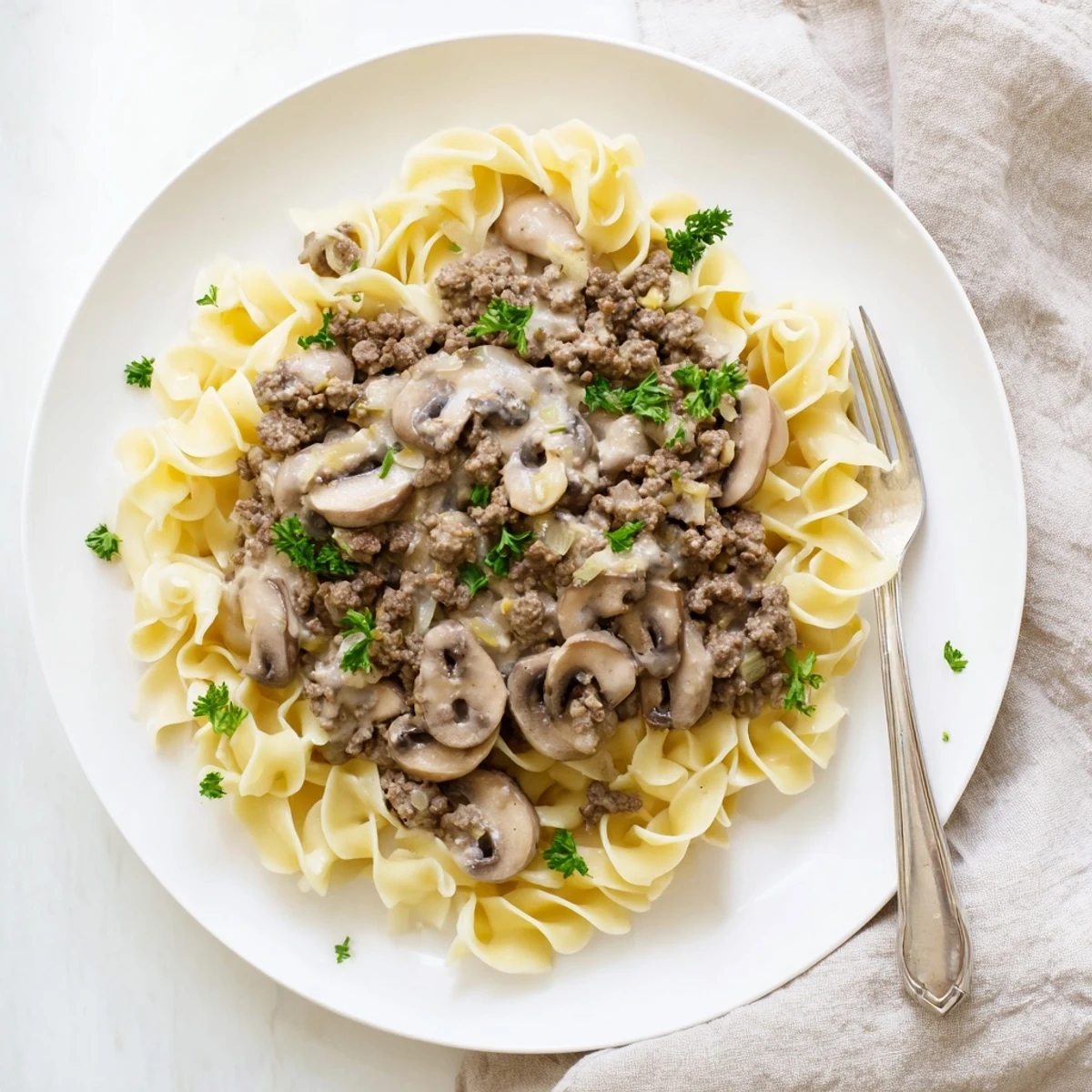 Rich hamburger stroganoff featuring beef and mushrooms plated over wide egg noodles