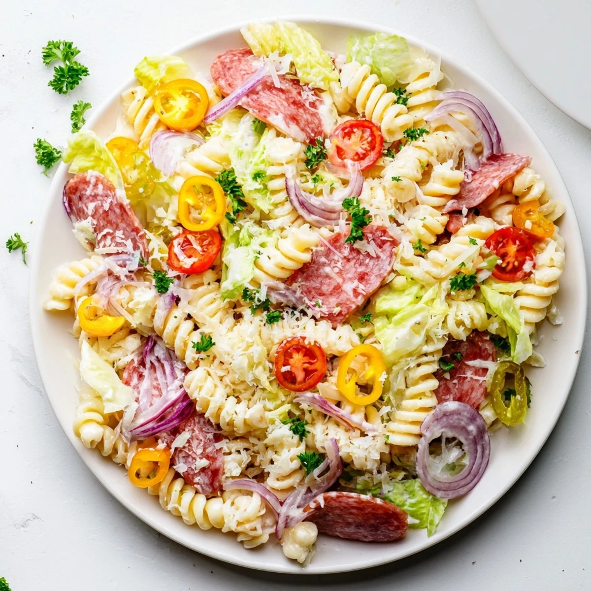 Colorful Italian grinder pasta salad with cured meats, cheese, and fresh vegetables in a creamy zesty dressing