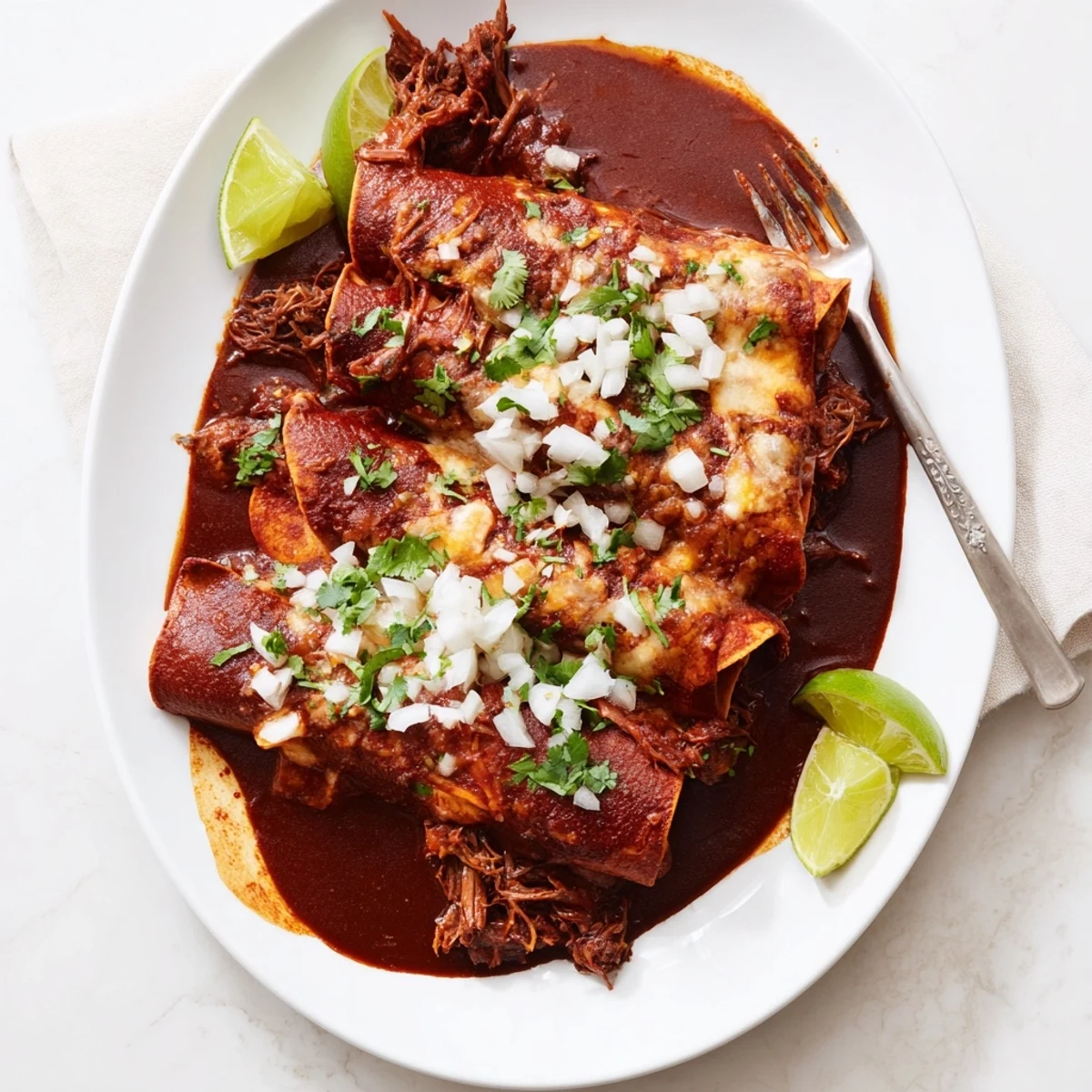 Golden corn tortillas filled with slow-cooked birria beef, smothered in rich consommé and bubbling cheese