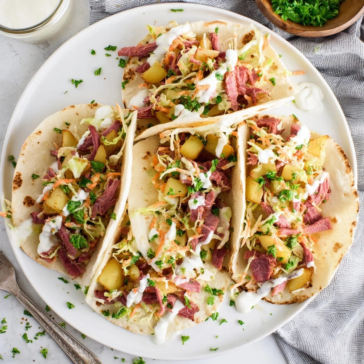 Warm corned beef tacos featuring crisp diced potatoes and tangy cabbage slaw on flour tortillas