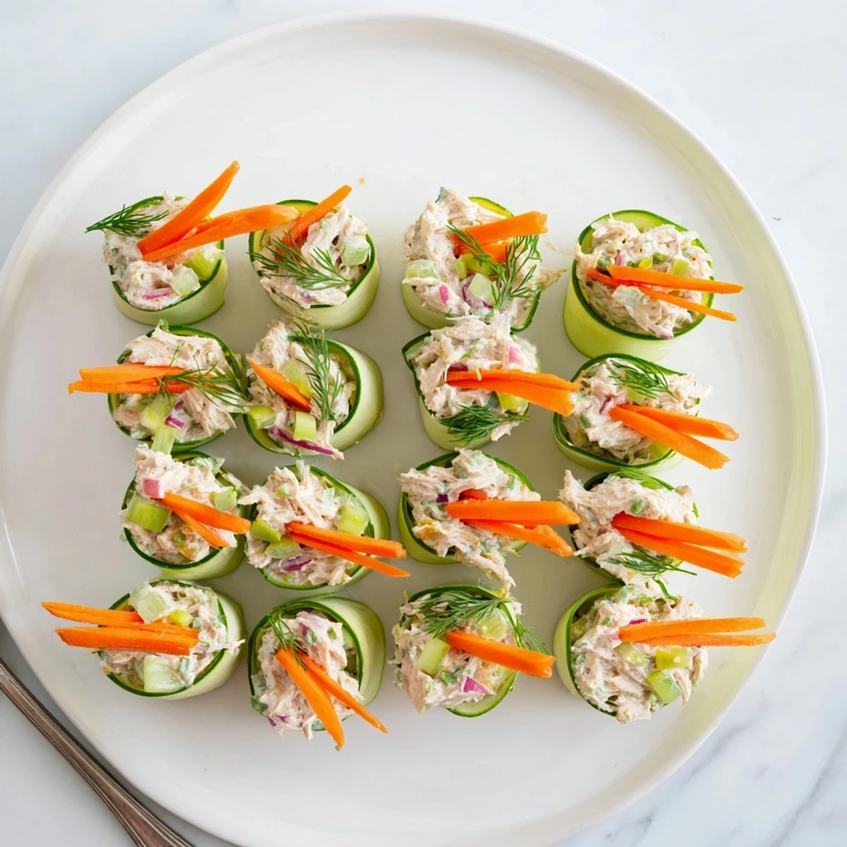 Fresh cucumber ribbons wrapped around creamy chicken salad with dill and celery