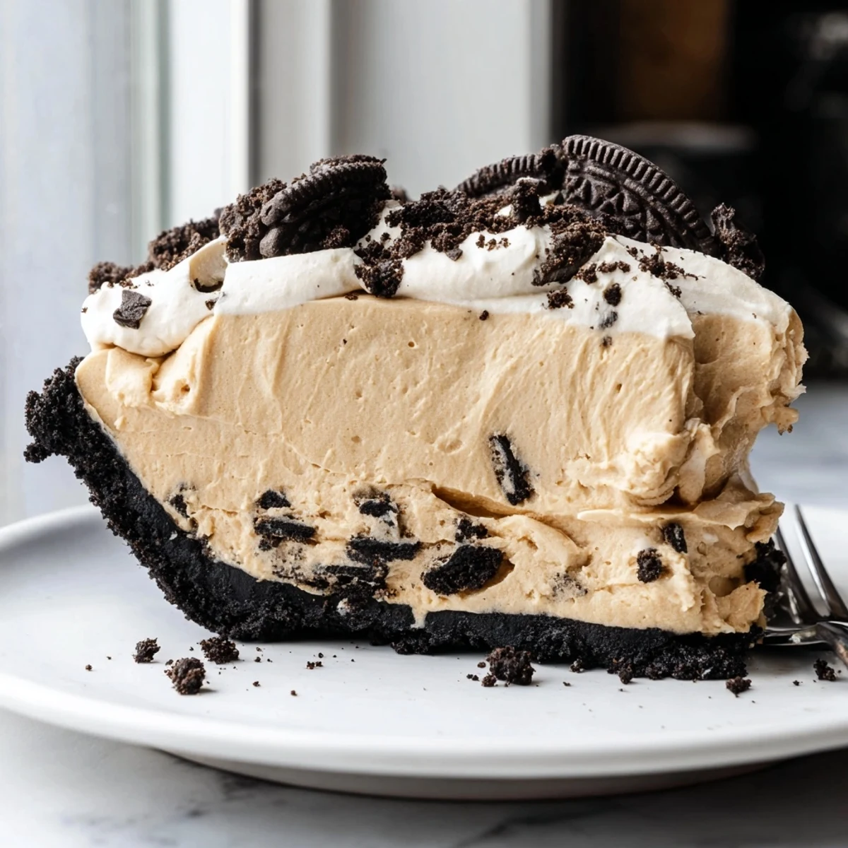Slice of no-bake peanut butter Oreo pie showing the rich creamy filling