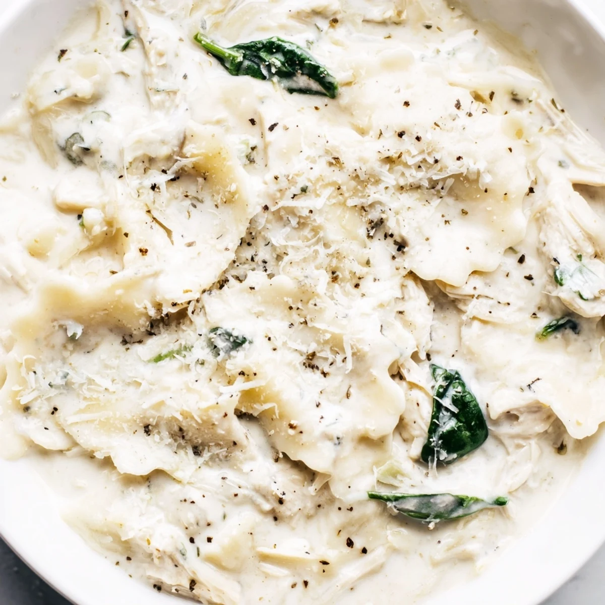 Creamy white lasagna soup in a white bowl with melted cheese and tender noodles