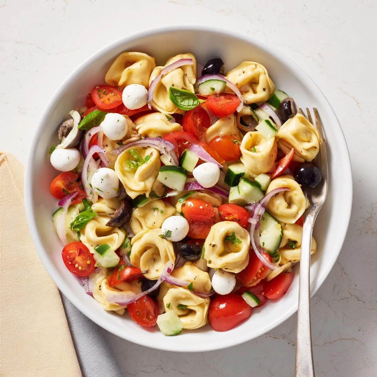 Creamy cheese tortellini pasta salad tossed with crisp vegetables and mozzarella in herbal vinaigrette