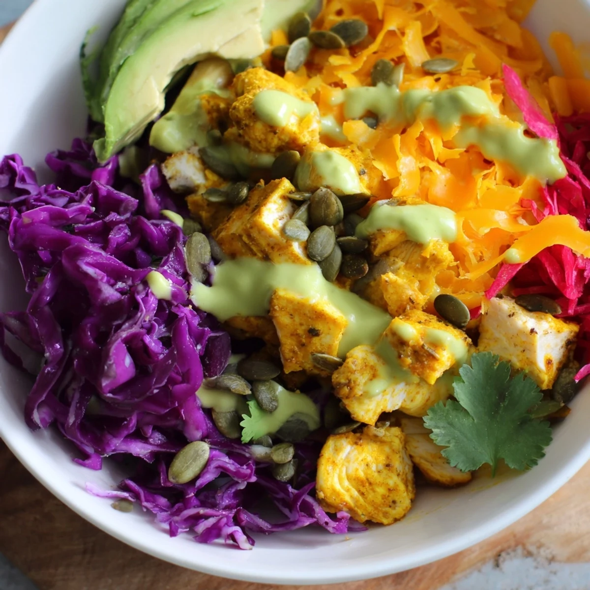 Colorful keto bowls loaded with fresh vegetables, seasoned chicken, and creamy avocado dressing