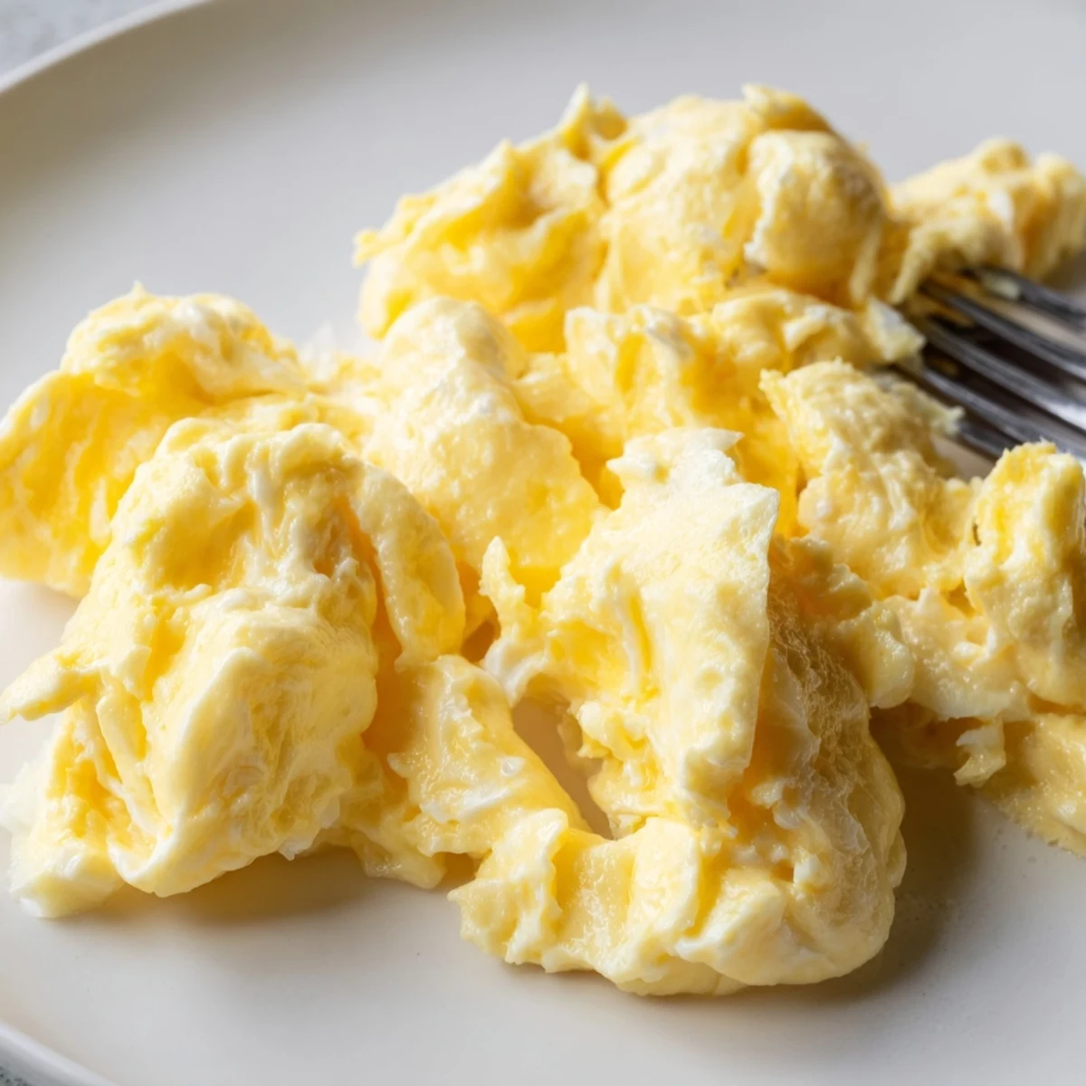 Soft yellow scrambled eggs topped with cracked pepper and fresh chives