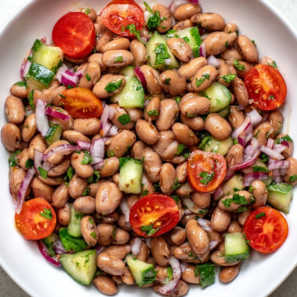 Fresh pinto bean salad topped with diced cucumber and tangy cumin vinaigrette