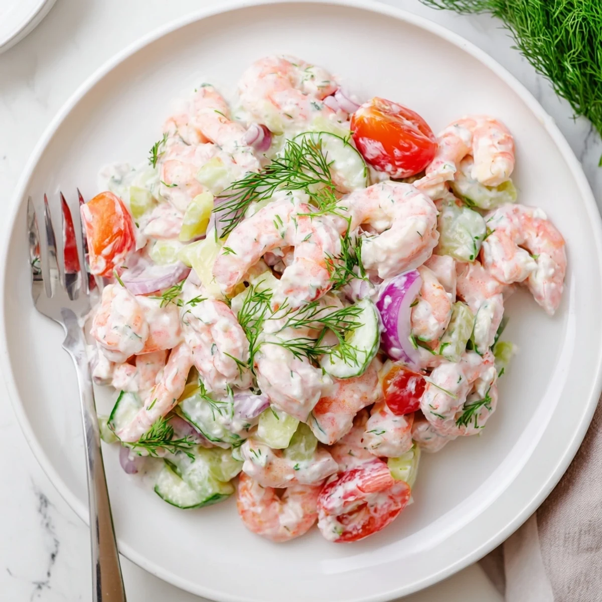 Pink shrimp salad recipe served chilled with crisp celery, tomatoes, and creamy lemon dressing