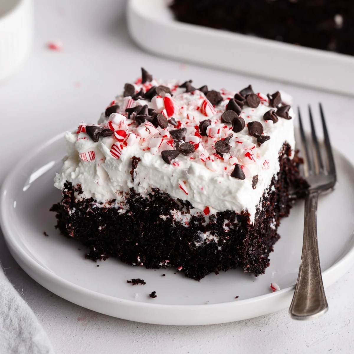 Sliced Peppermint Poke Cake on a plate, rich chocolate and mint.