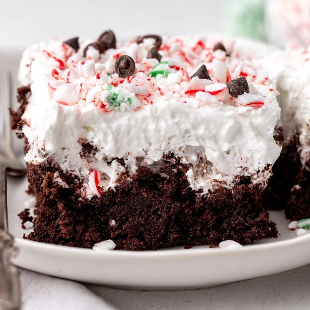 Holiday platter of Peppermint Poke Cake topped with crushed mint candy.