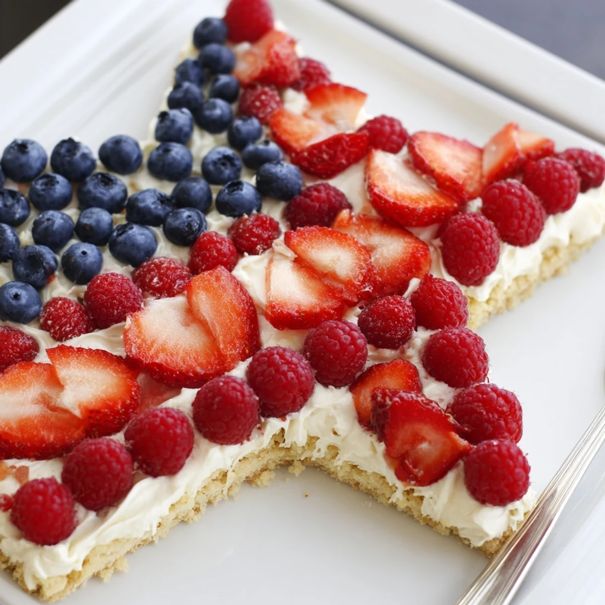 Sugar Cookie Flag Fruit Pizza with glossy berries and creamy frosting, sliced.