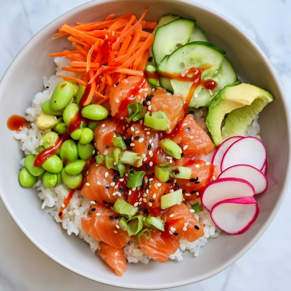 Healthy salmon and avocado poke bowl served over seasoned rice with radish and edamame