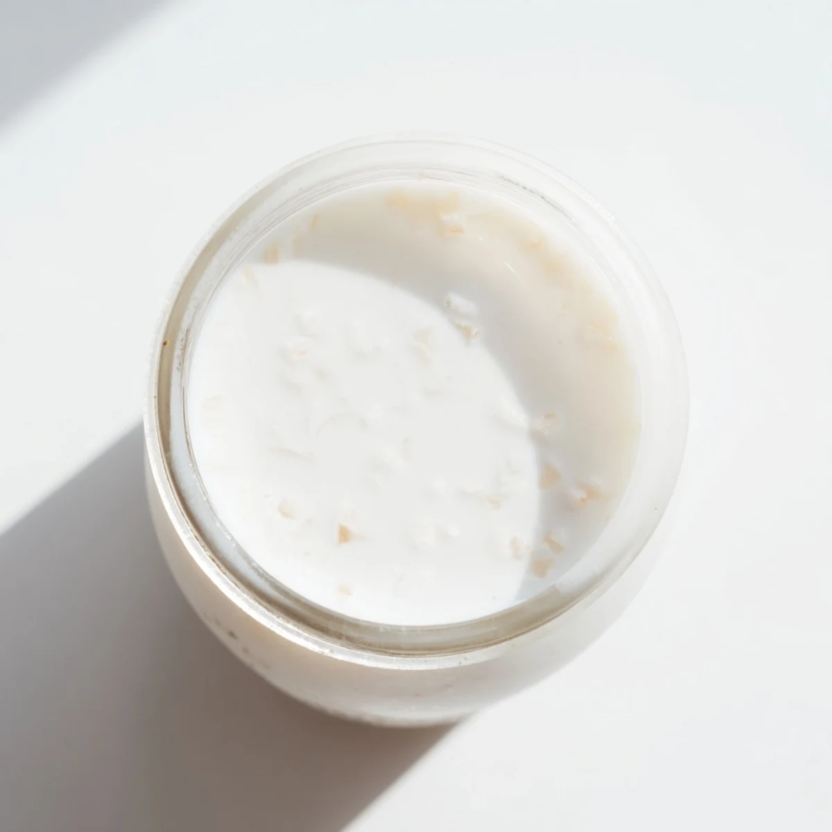 Homemade coconut milk recipe strained through cheesecloth into a bowl, showing smooth plant-based dairy alternative