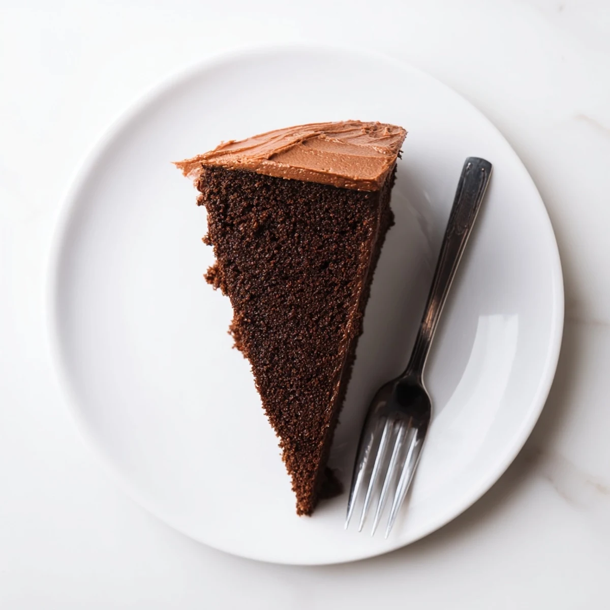 Rich moist chocolate cake with mayonnaise sliced on a white serving plate