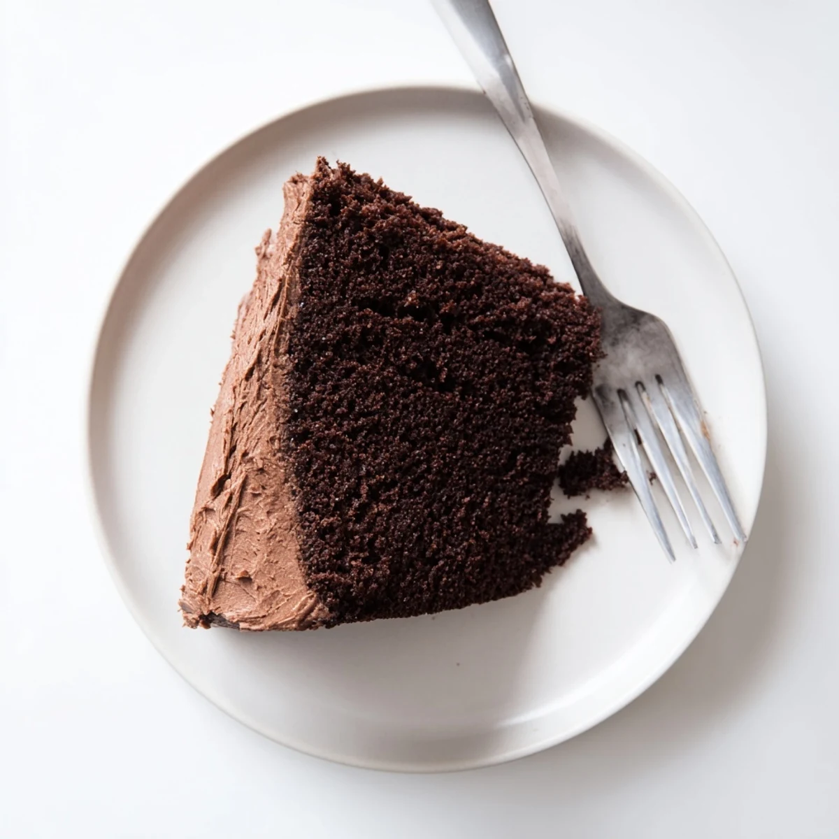 Decadent chocolate mayonnaise cake topped with creamy frosting and chocolate shavings