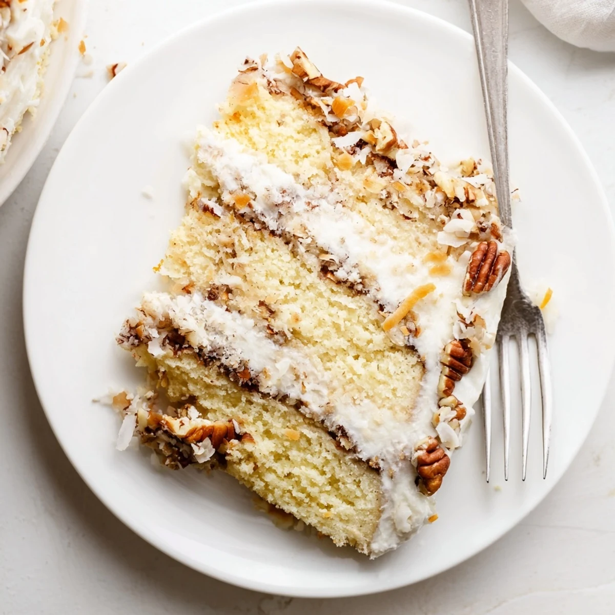 Homemade Italian cream cake slice showcasing creamy frosting and nutty coconut pecan topping