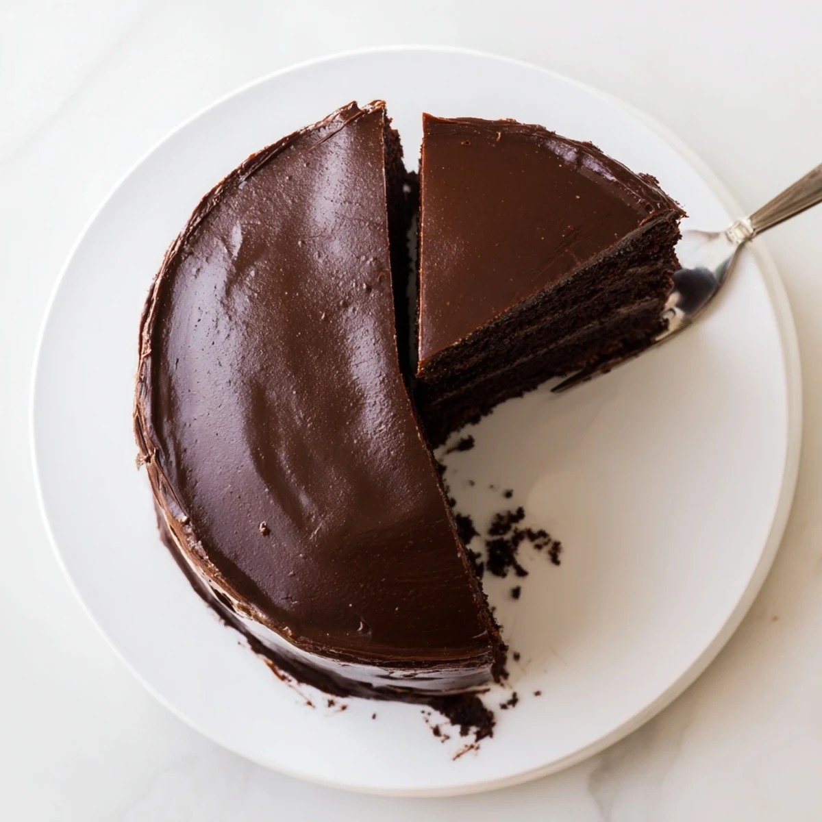 Decadent double-layer Matildas Chocolate Cake topped with creamy cocoa buttercream on white plate