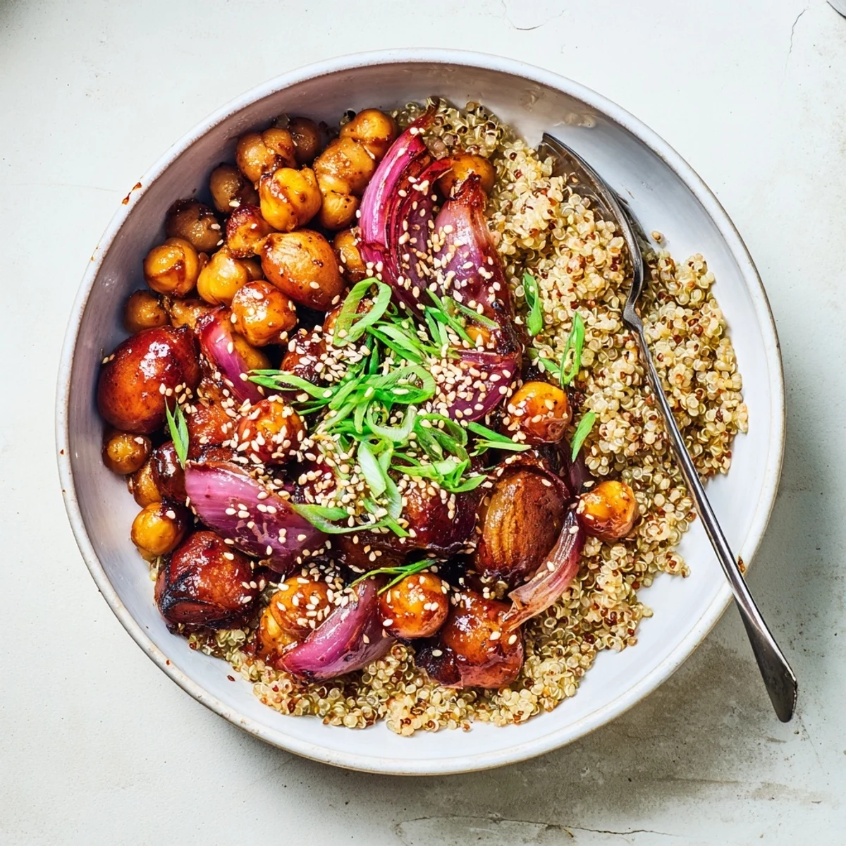 Roasted gochujang potatoes and crispy chickpeas served in a bowl with quinoa