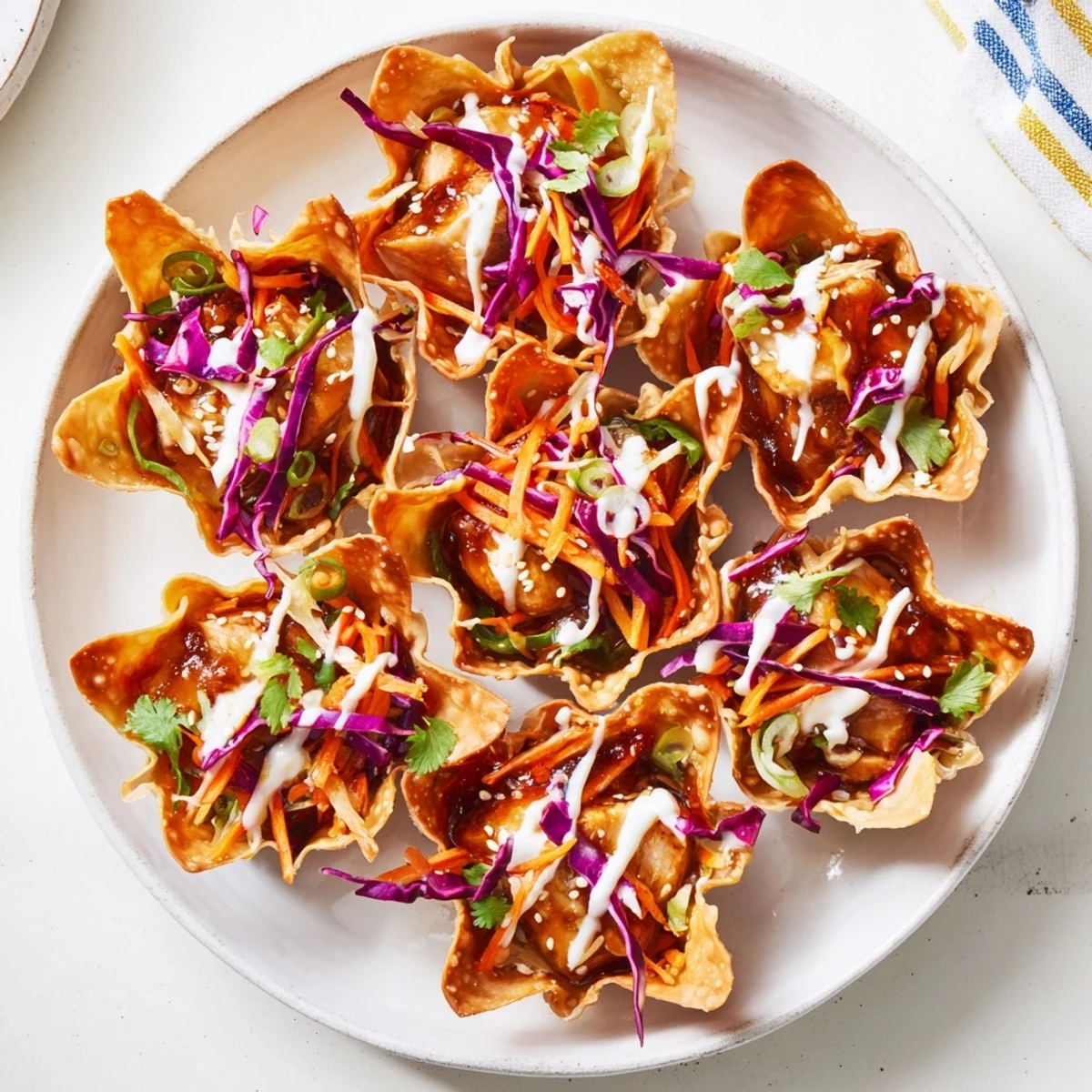 Golden crispy Asian chicken wonton tacos topped with colorful cabbage slaw and spicy mayo drizzle