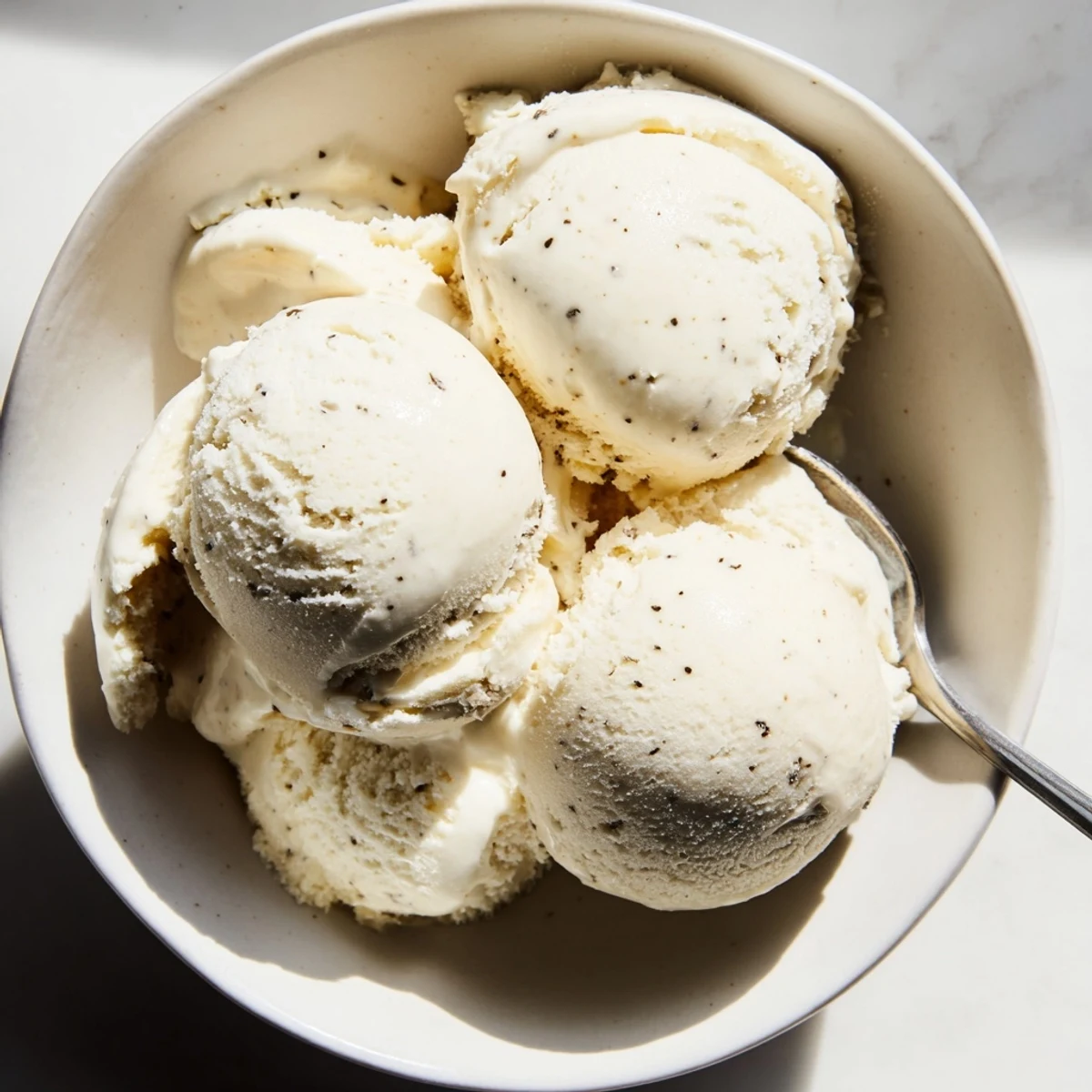 Homemade vanilla ice cream recipe served in a chilled bowl with fresh summer berries
