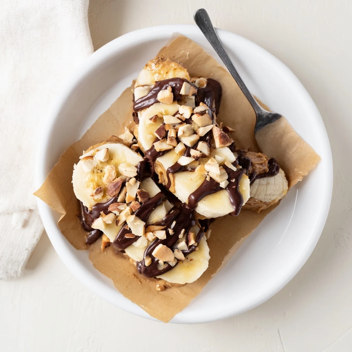 Chocolate Peanut Butter Banana slices drizzled with glossy chocolate, chopped peanuts.