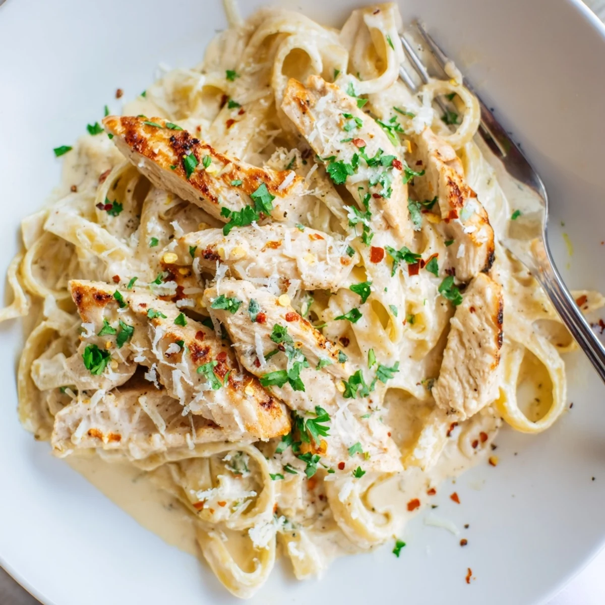 Steaming bowl of Creamy Garlic Parmesan Chicken Pasta coated in silky garlic butter cream sauce