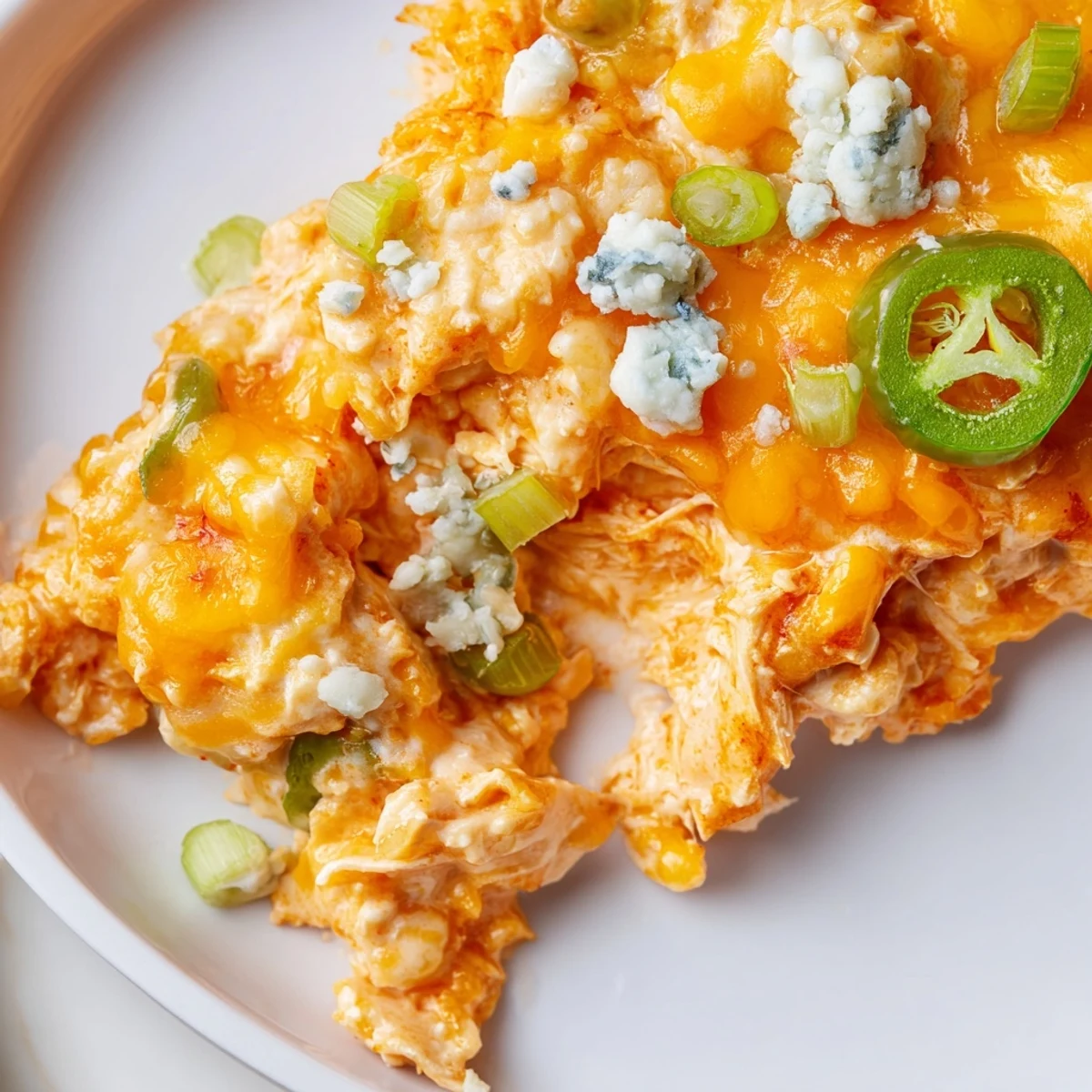 Bubbling golden cheese tops this spicy jalapeno buffalo chicken casserole fresh from the oven