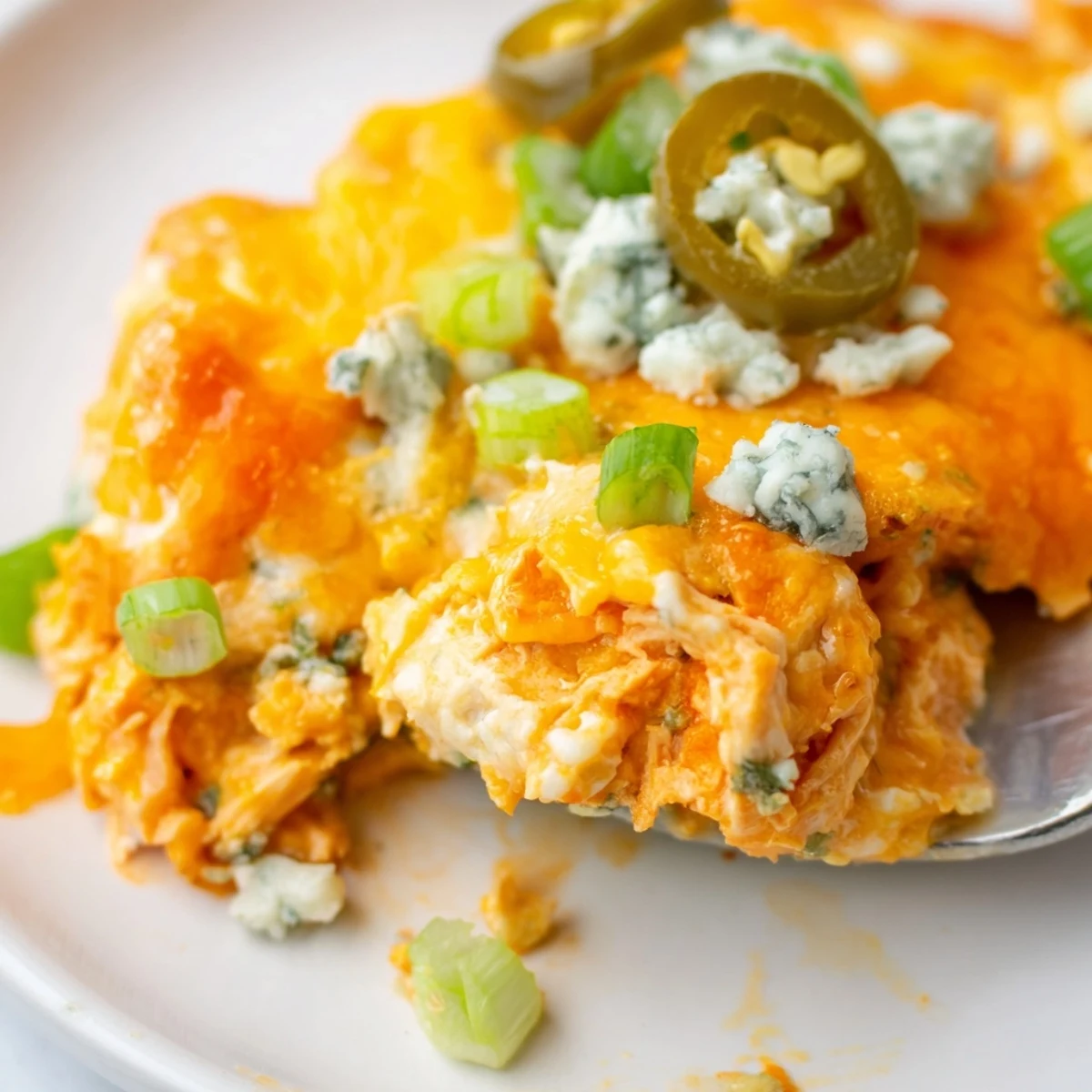 Creamy jalapeno buffalo chicken casserole with melted cheddar and blue cheese crumbles