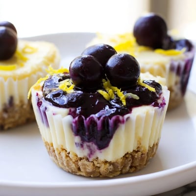 Creamy mini lemon blueberry cheesecakes with swirled fruit filling in paper liners ready to serve