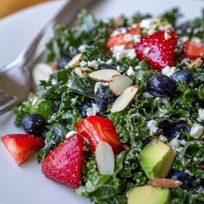 Hearty chopped kale tossed with juicy strawberries, avocado, and a glossy lemon-honey vinaigrette.
